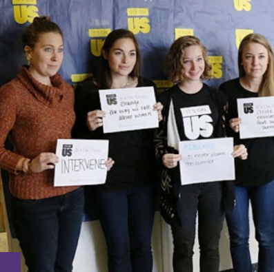 Group of people standing holding up signs
