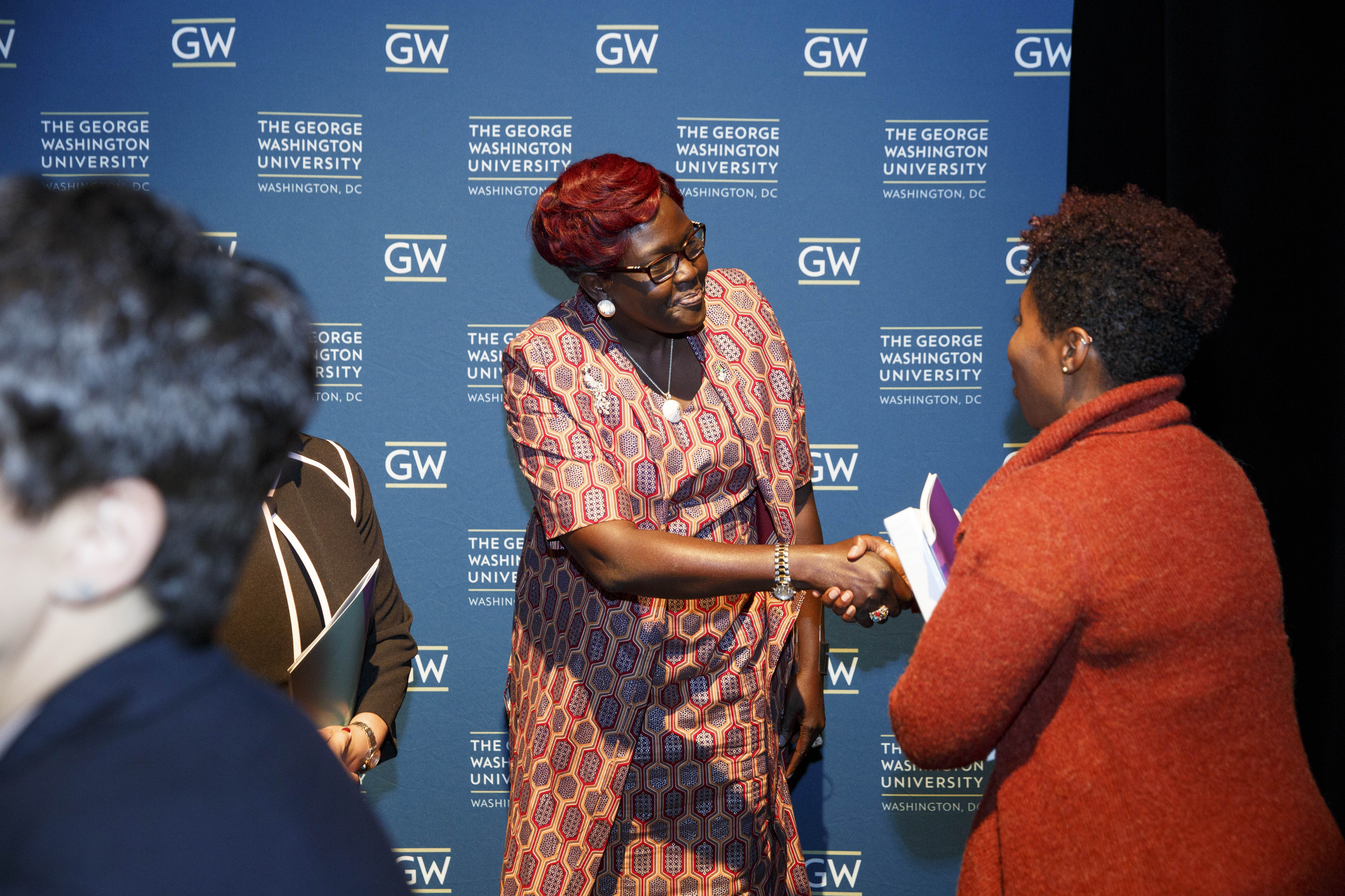 Speakers greet one another