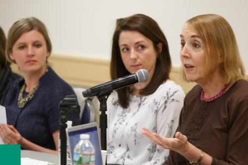 Woman speaking on a panel at a symposium