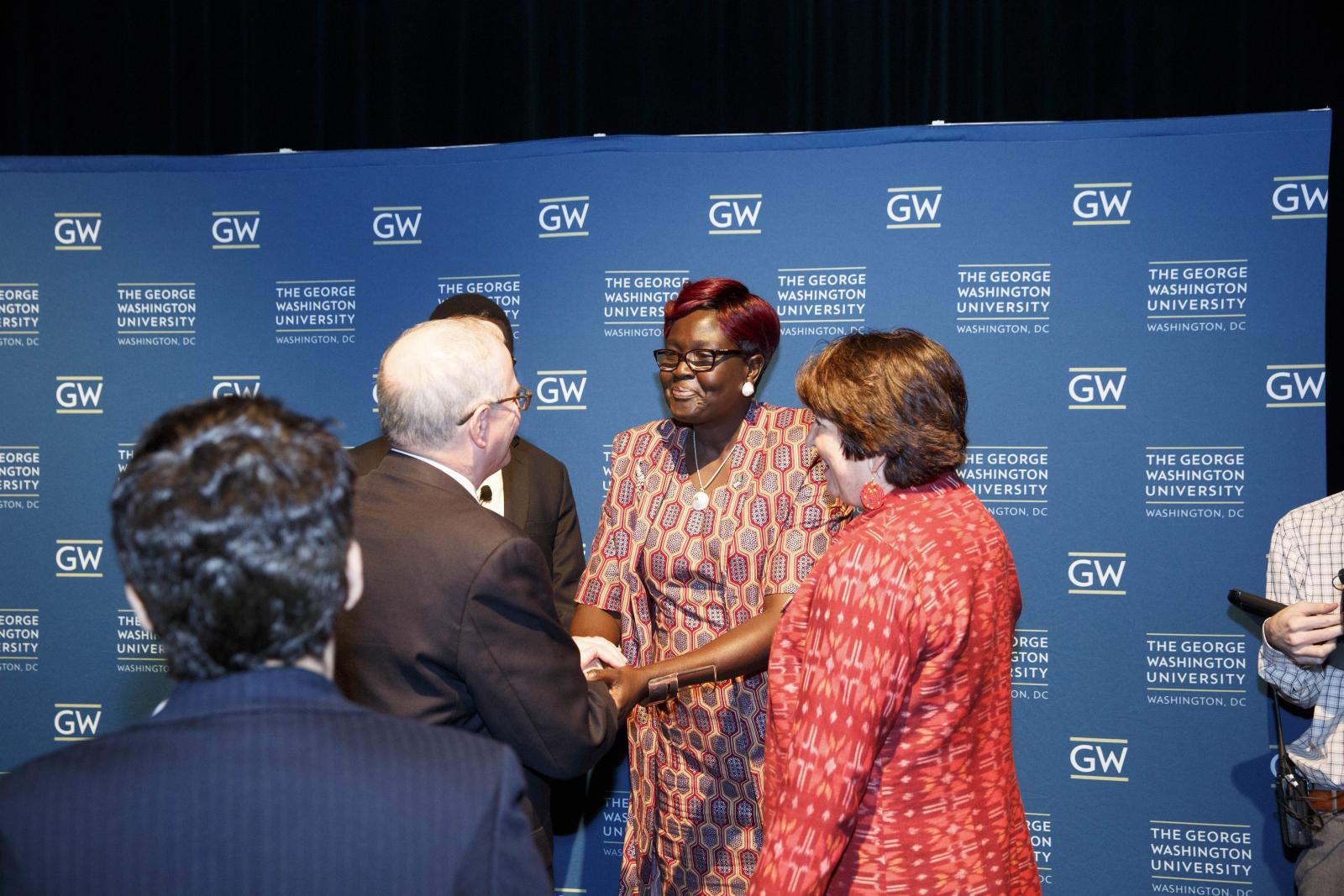 Speakers greet one another